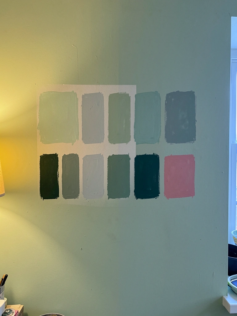 Parede pintada de verde dividida entre luz quente e luz fria, evidenciando a variação do tom